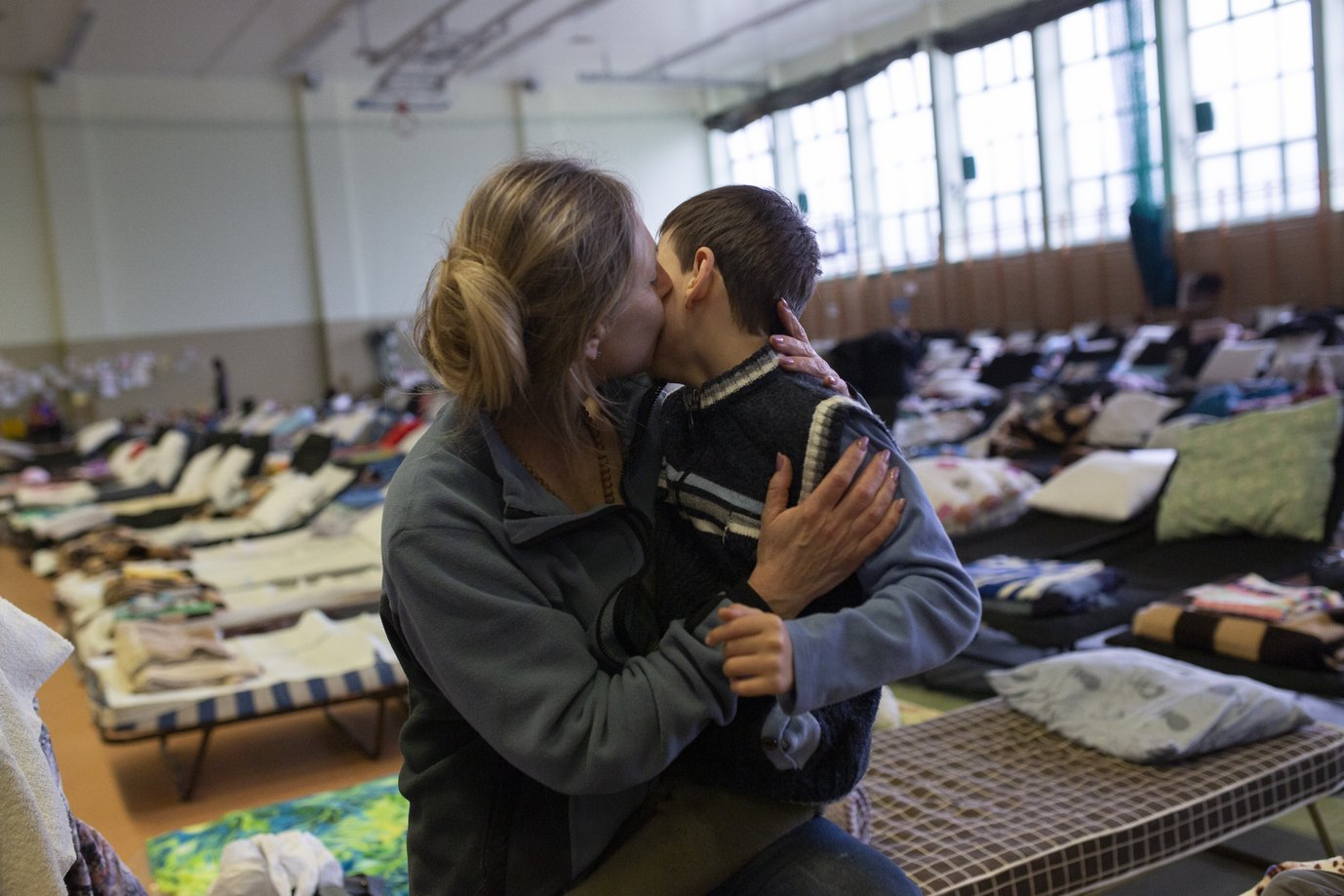 Refugee from Ukraine hugs her son in the reception center in Medyka