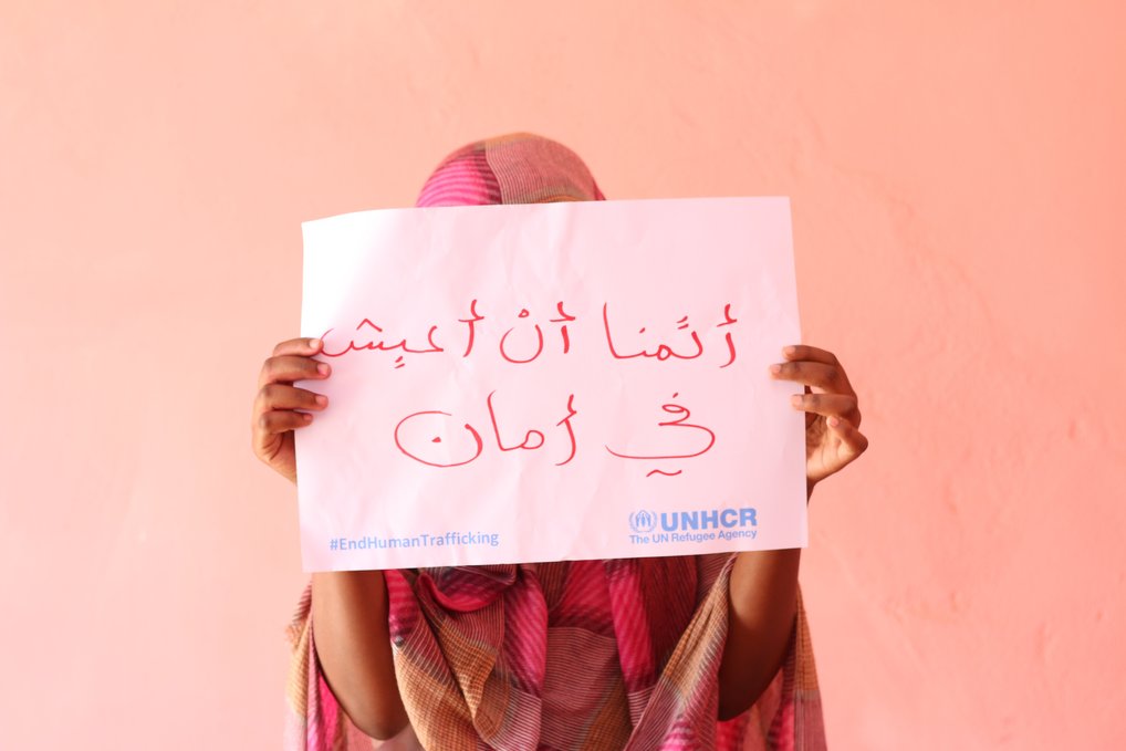 Nineteen-year-old Rumaysa from the host community holds up a sign saying "I want to live in safety” during the UNHCR campaign against human trafficking in east Sudan.