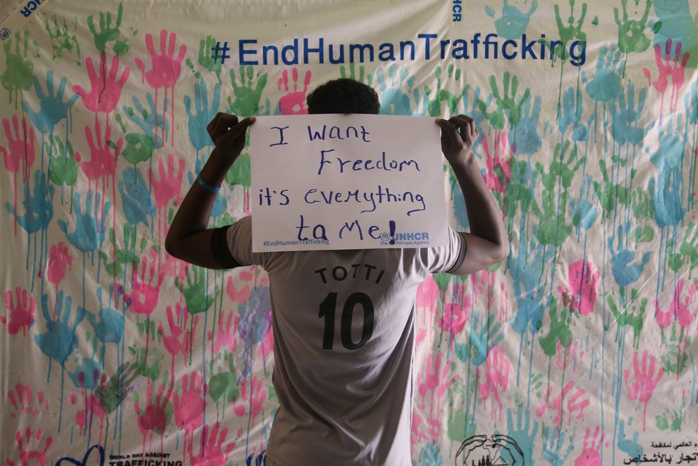 17-year-old Nahom, who survived human trafficking, holds up a sign saying  “I want freedom. It is everything for me” during the UNHCR campaign in east Sudan. 