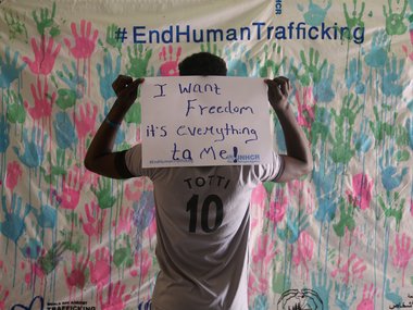 17-year-old Nahom, who survived human trafficking, holds up a sign saying “I want freedom. It is everything for me” during the UNHCR campaign in east Sudan.