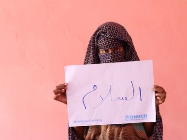 19-year-old Amuna from the host community holds up a sign saying "Peace” during the UNHCR campaign against human trafficking in east Sudan.