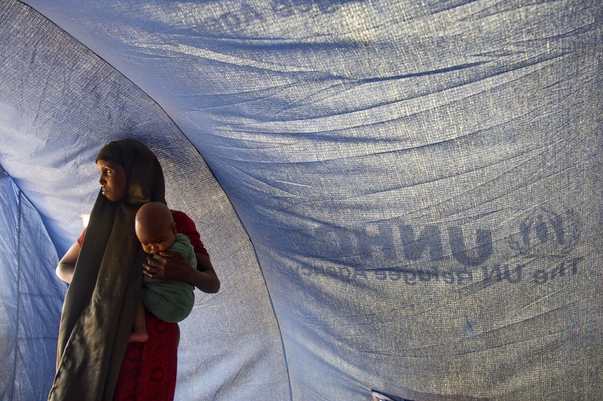 A Somali refugee stands inside a tent with her baby in Dollo Ado, Ethiopia.Fleeing drought and famine in their home country, thousands of Somalis have taken up residence across the border in Dollo Ado where a complex of camps is assisted by the UN Refugee Agency (UNHCR). A Somali refugee stands inside a tent with her baby in Dollo Ado, Ethiopia.Fleeing drought and famine in their home country, thousands of Somalis have taken up residence across the border in Dollo Ado where a complex of camps is assisted by the UN Refugee Agency (UNHCR).